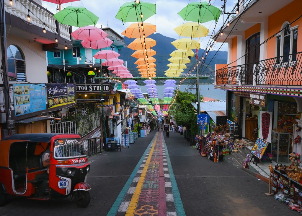 Colorful umbrellas cover the painted pavement along the main shopping street of San Juan La Laguna on the shores of Lake Atitlán in Guatemala.