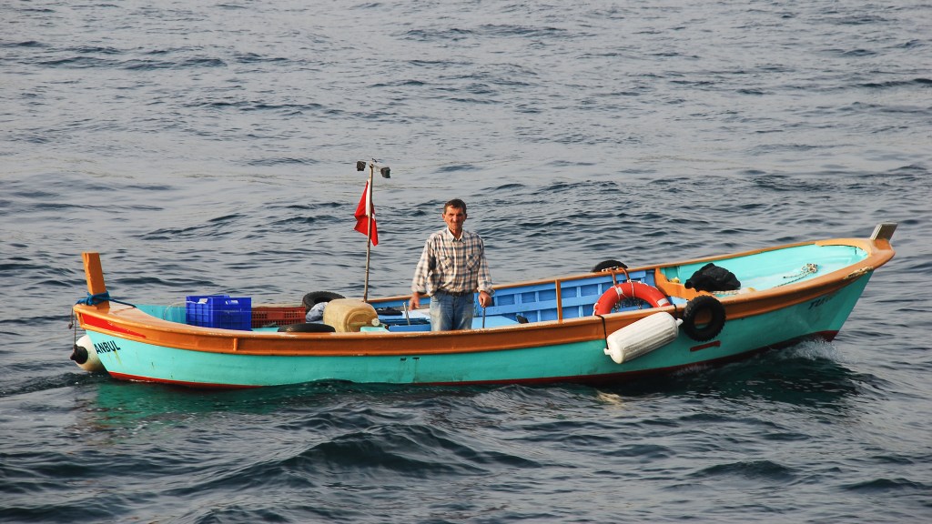 A lone fisherman drifts across the Bosphorus in a turquoise skiff.