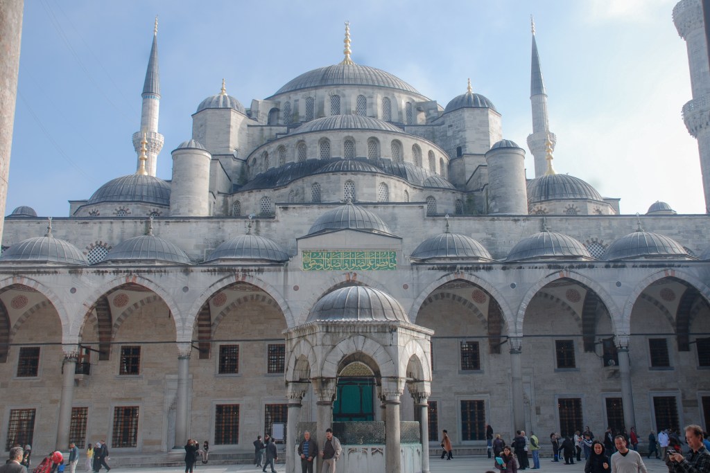 Cascading domes of the Blue Mosque give background to its open courtyard.